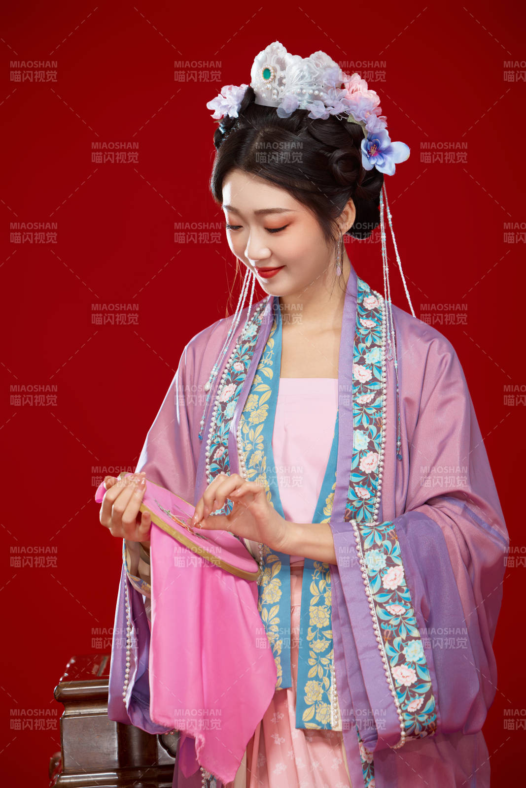 红色背景下身穿中国明朝簪花发饰汉服的美女