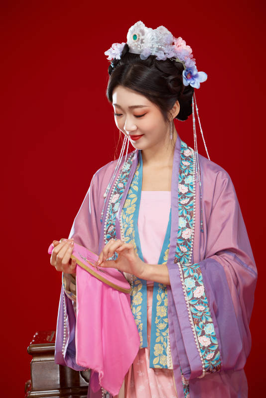 红色背景下身穿中国明朝簪花发饰汉服的美女