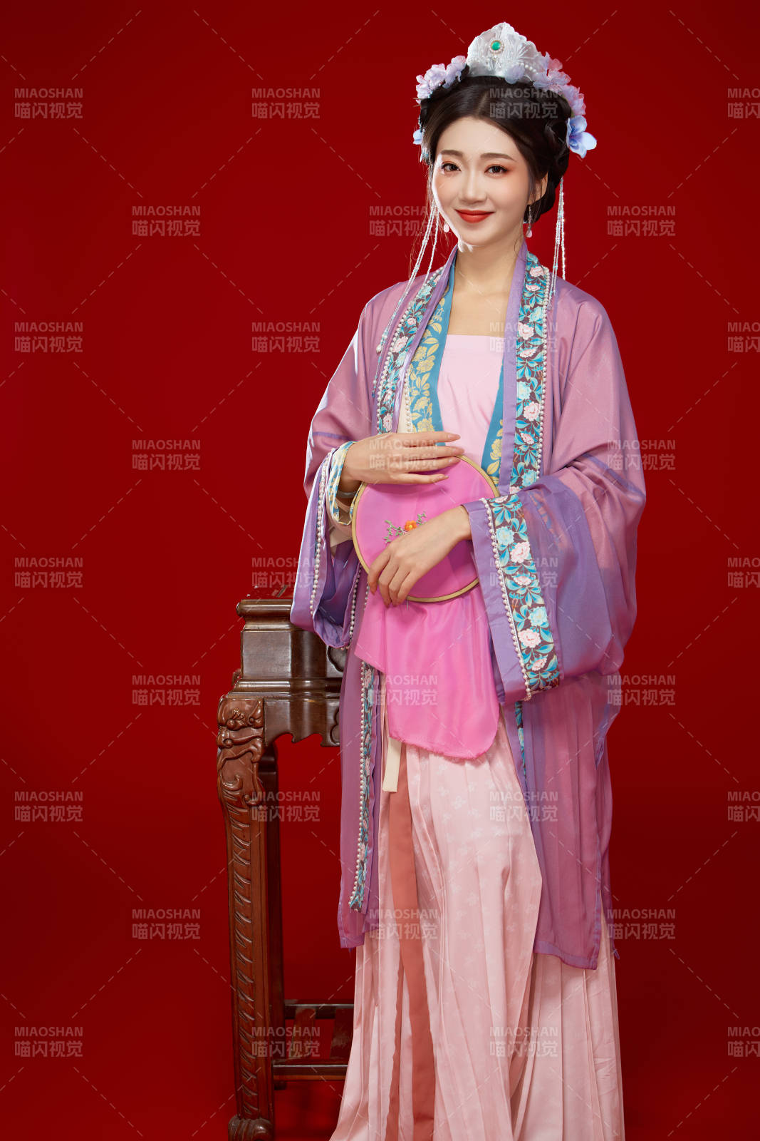 红色背景下身穿中国明朝簪花发饰汉服的美女