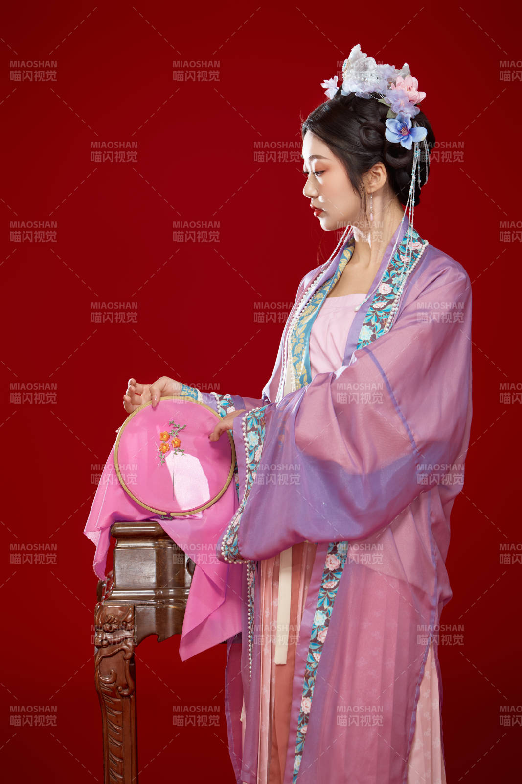 红色背景下身穿中国明朝簪花发饰汉服的美女