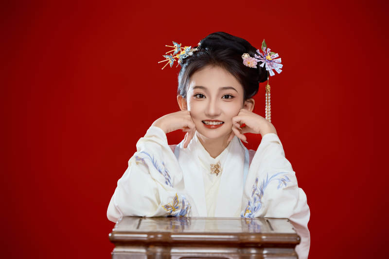 红色背景下穿着中国明朝明制汉服服饰的少女