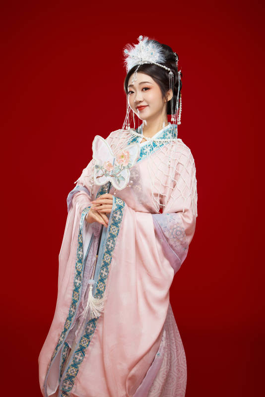 红色背景下身穿中国明朝簪花发饰汉服的美女