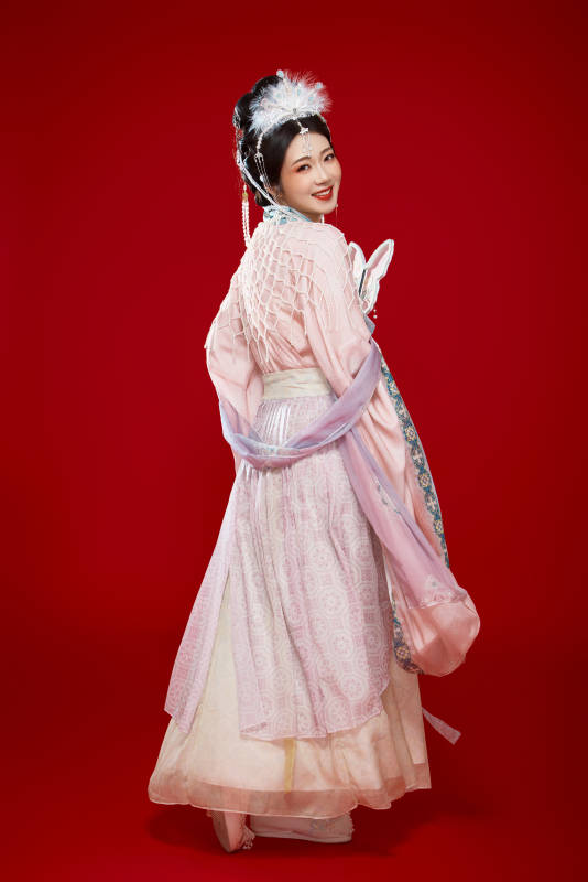 红色背景下身穿中国明朝簪花发饰汉服的美女