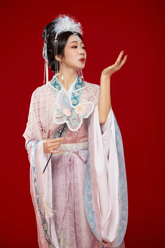 紅色背景下身穿中國明朝簪花發飾漢服的美女