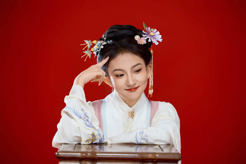 红色背景下穿着中国明朝明制汉服服饰的少女