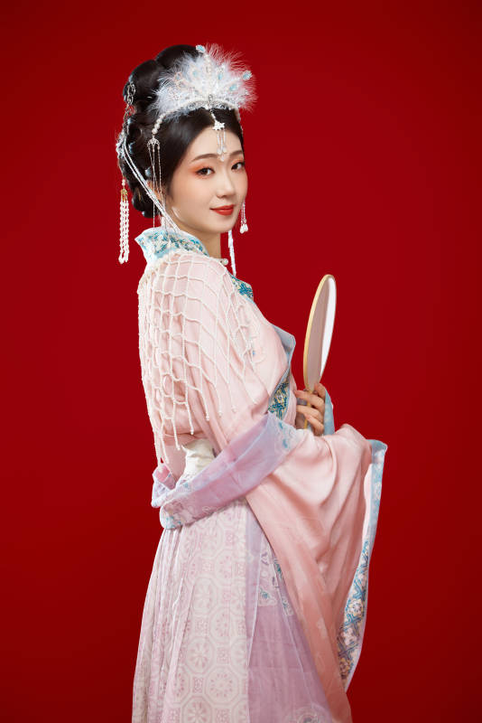 红色背景下身穿中国明朝簪花发饰汉服的美女