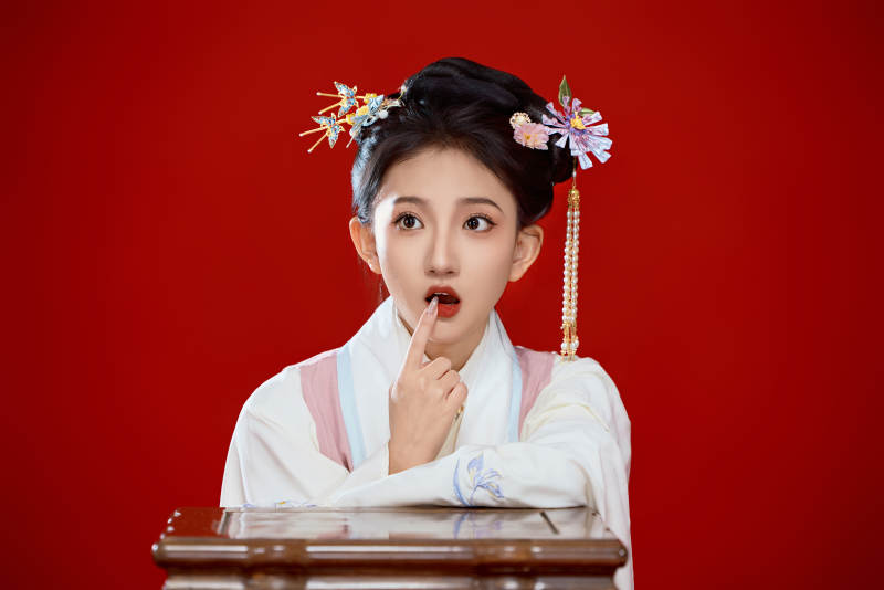 红色背景下穿着中国明朝明制汉服服饰的少女