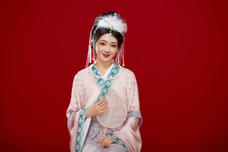 红色背景下身穿中国明朝簪花发饰汉服的美女