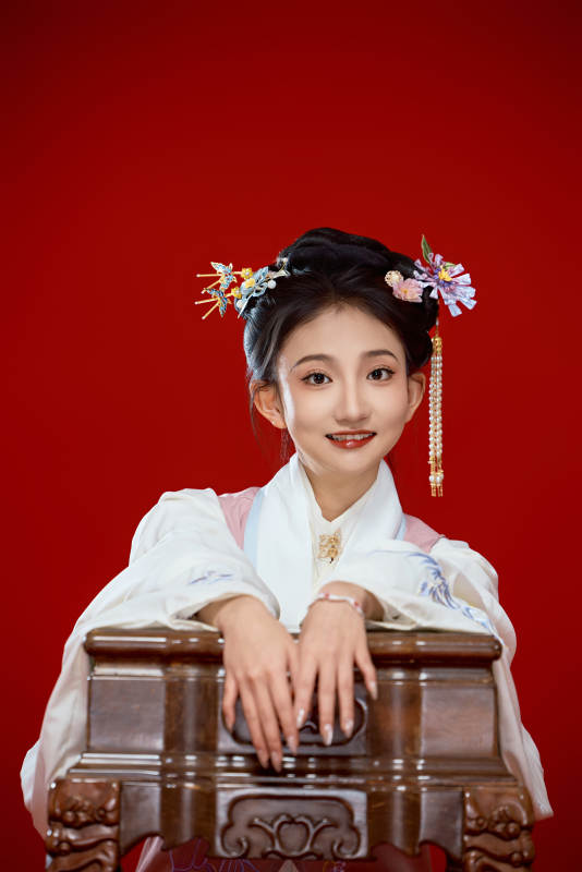 红色背景下穿着中国明朝明制汉服服饰的少女