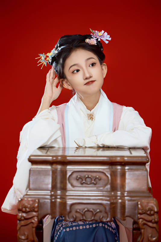 红色背景下穿着中国明朝明制汉服服饰的少女