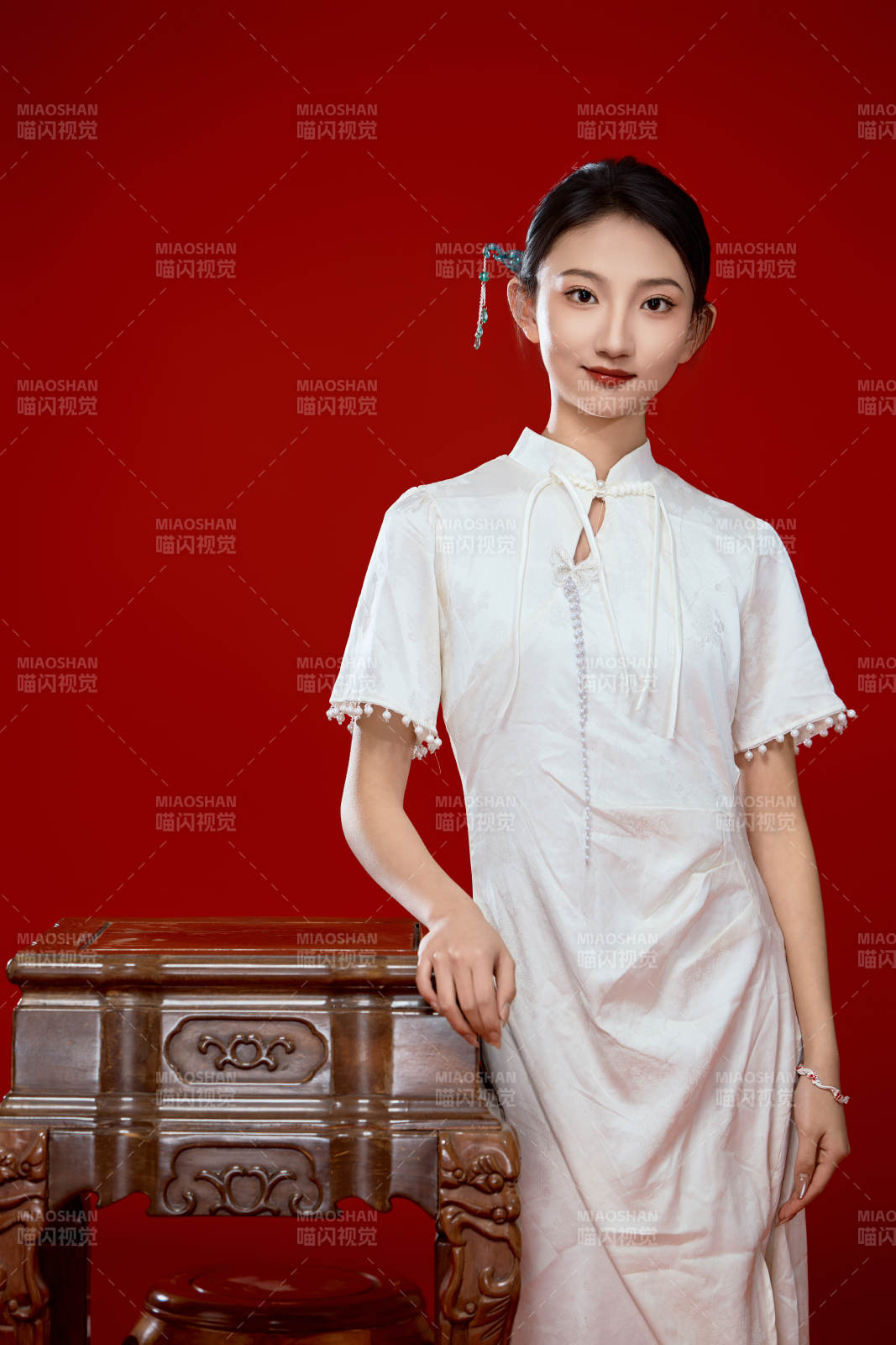 红色背景下穿着中式传统旗袍的美丽少女