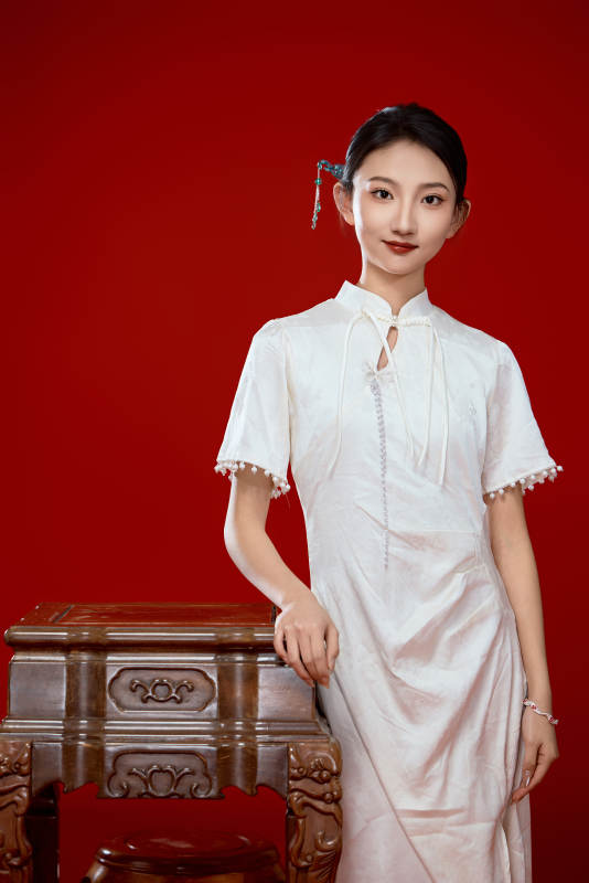 红色背景下穿着中式传统旗袍的美丽少女