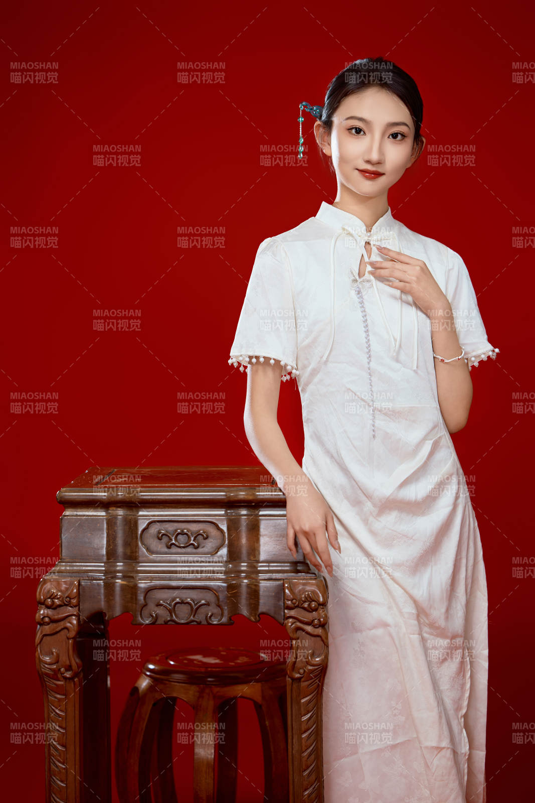 红色背景下穿着中式传统旗袍的美丽少女