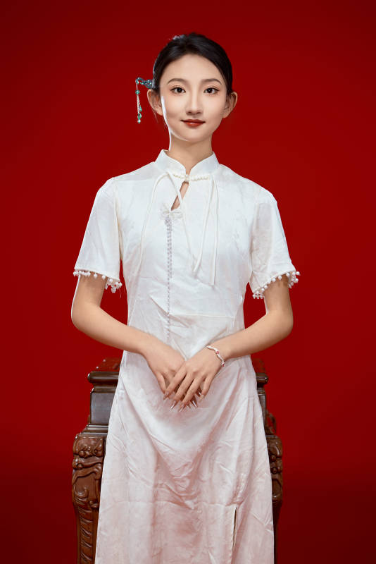 红色背景下穿着中式传统旗袍的美丽少女