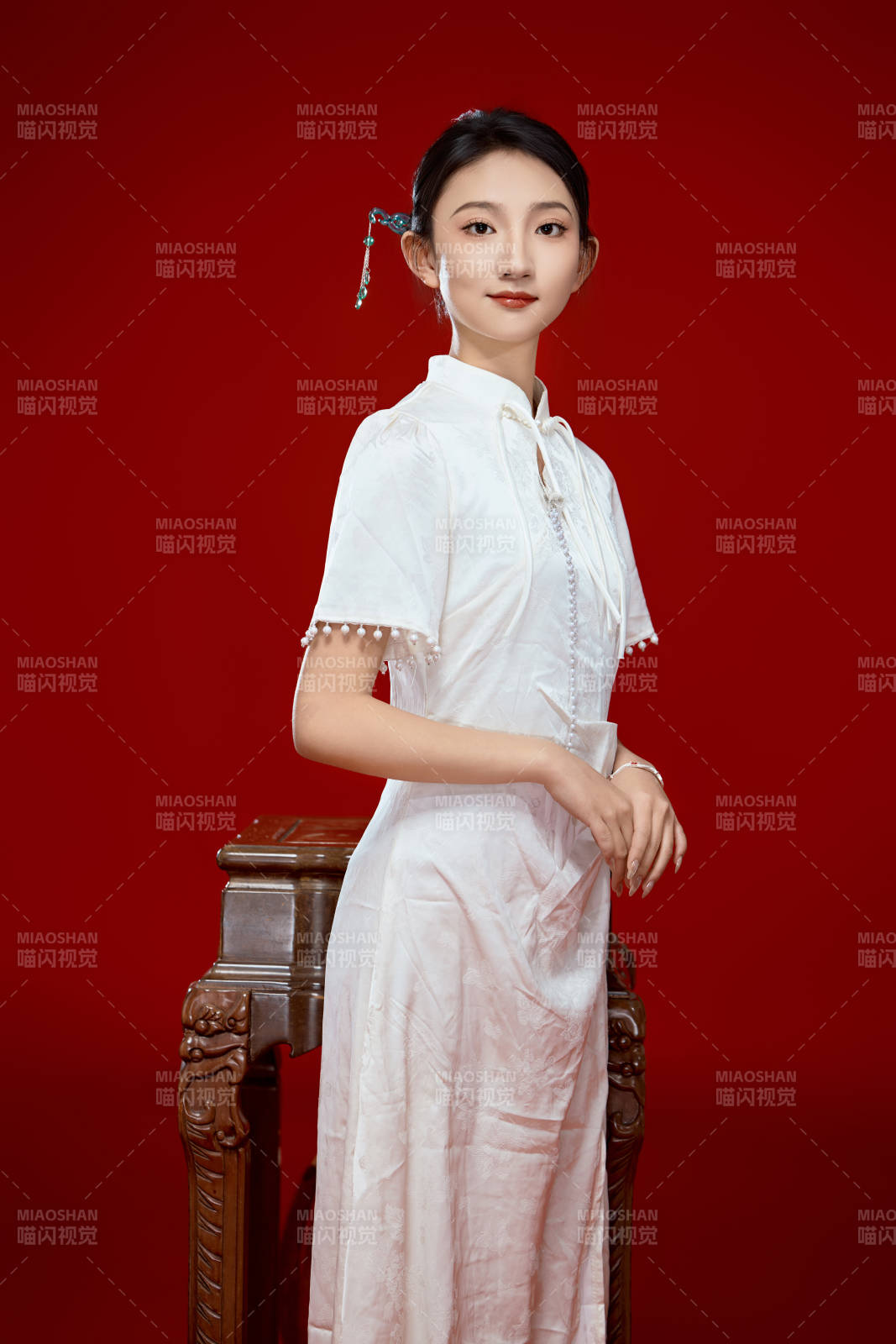 红色背景下穿着中式传统旗袍的美丽少女