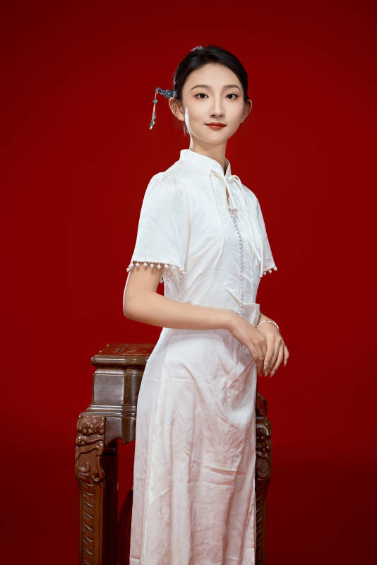 红色背景下穿着中式传统旗袍的美丽少女