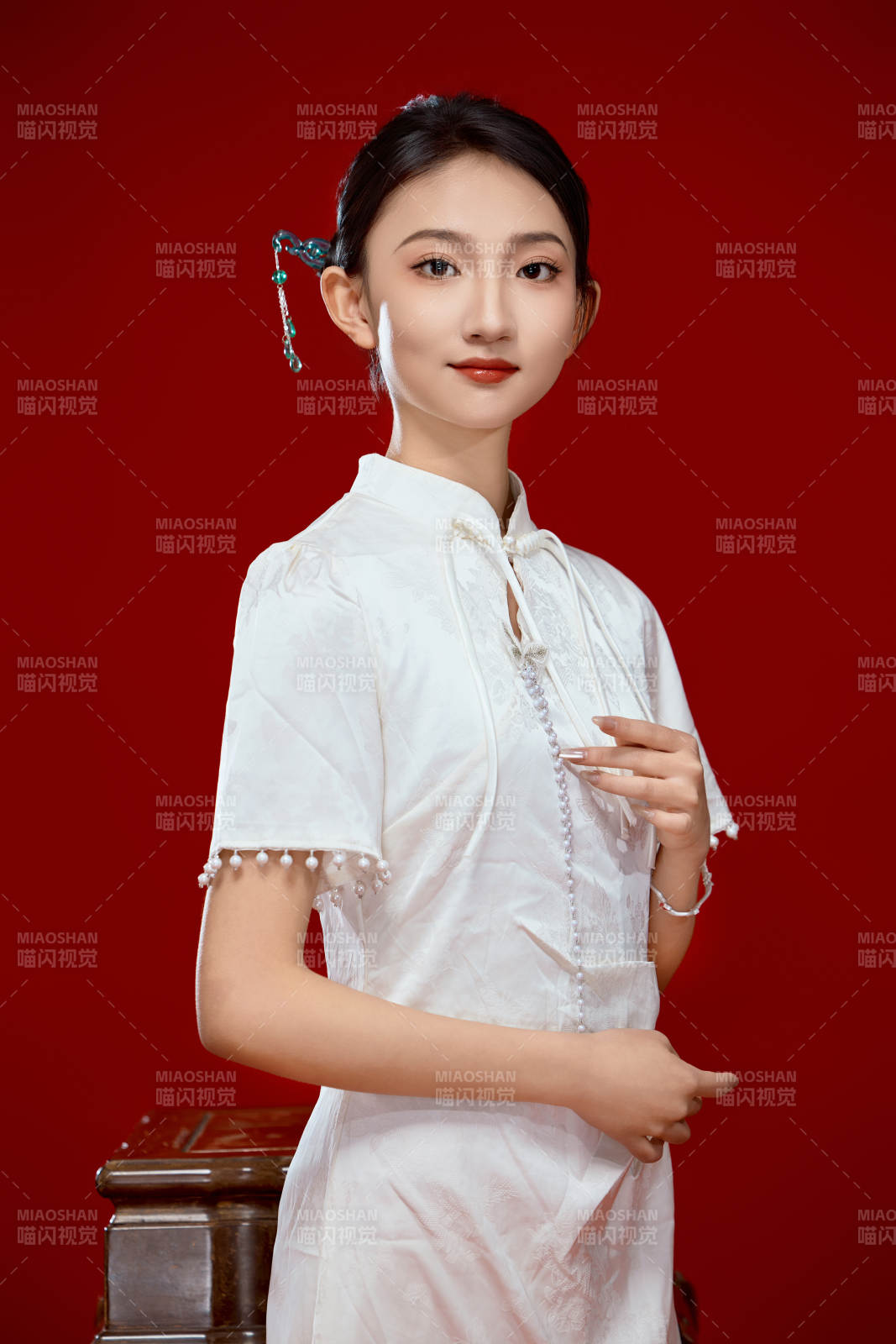 红色背景下穿着中式传统旗袍的美丽少女