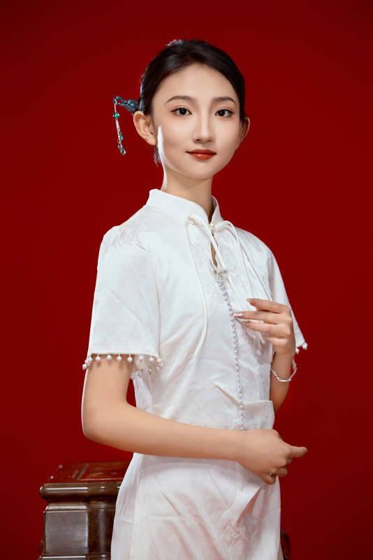 红色背景下穿着中式传统旗袍的美丽少女