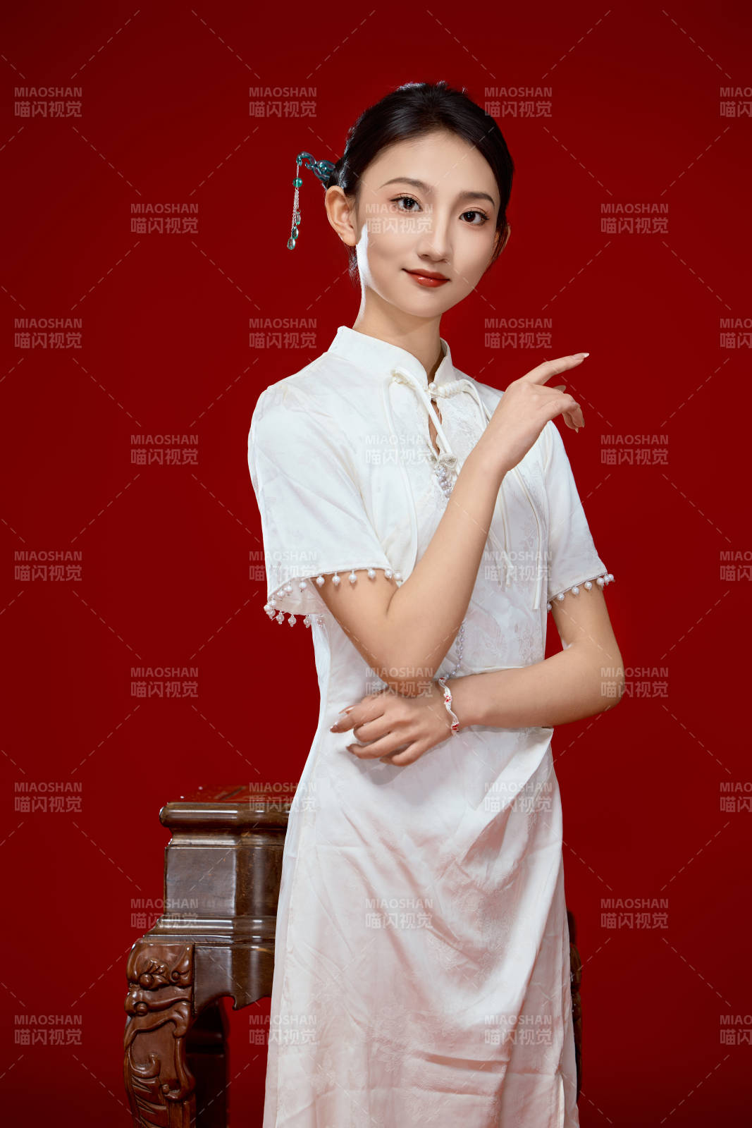 紅色背景下穿著中式傳統旗袍的美麗少女-攝影圖