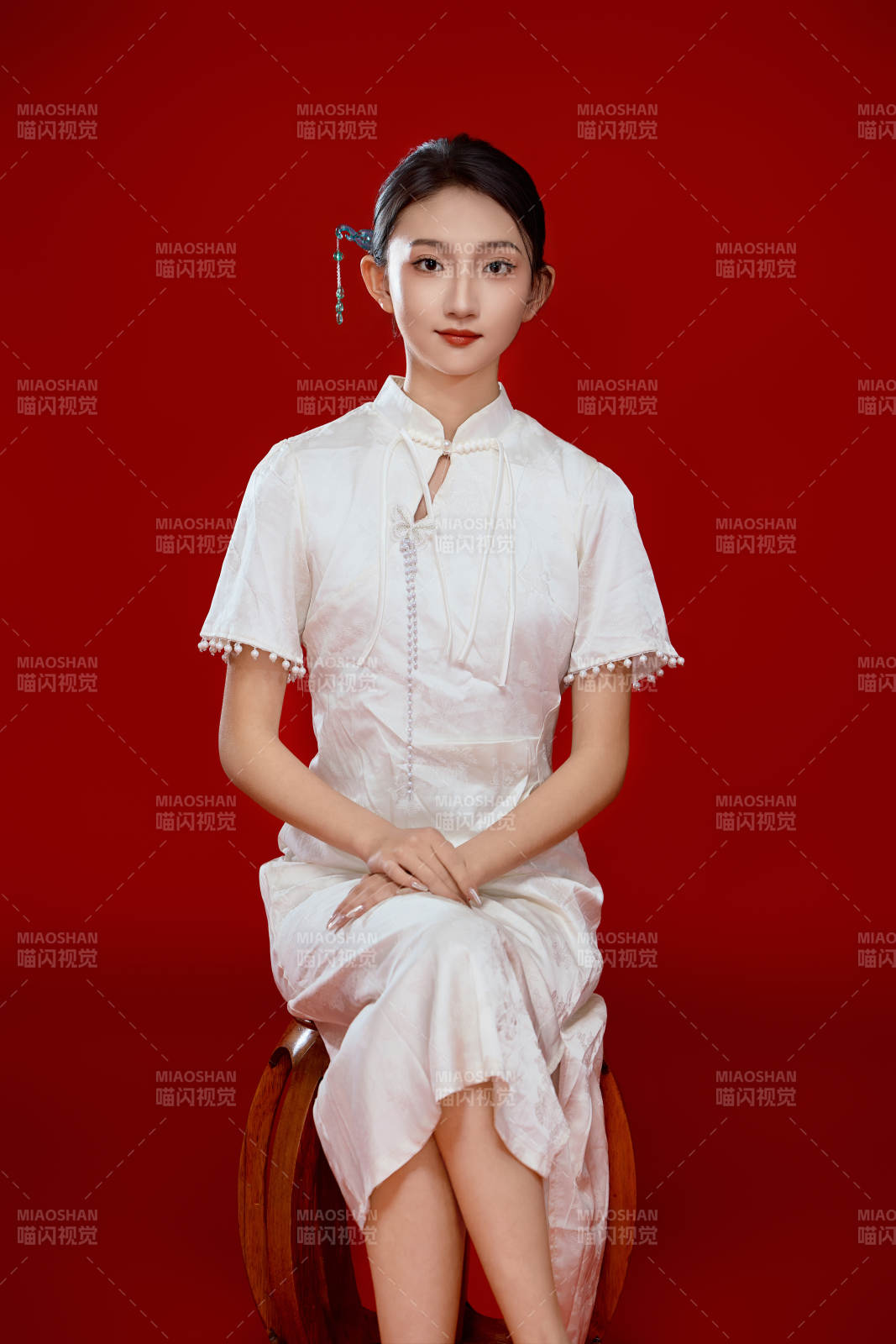 紅色背景下穿著中式傳統(tǒng)旗袍的美麗少女