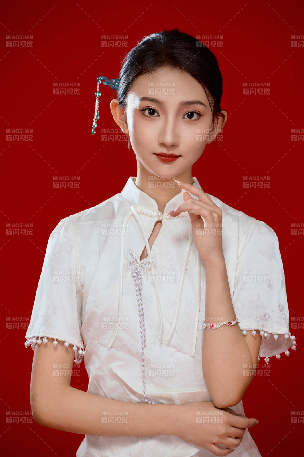 红色背景下穿着中式传统旗袍的美丽少女