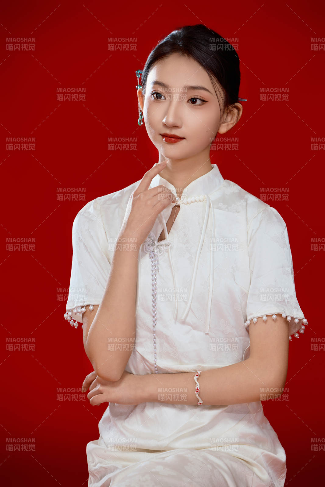 红色背景下穿着中式传统旗袍的美丽少女