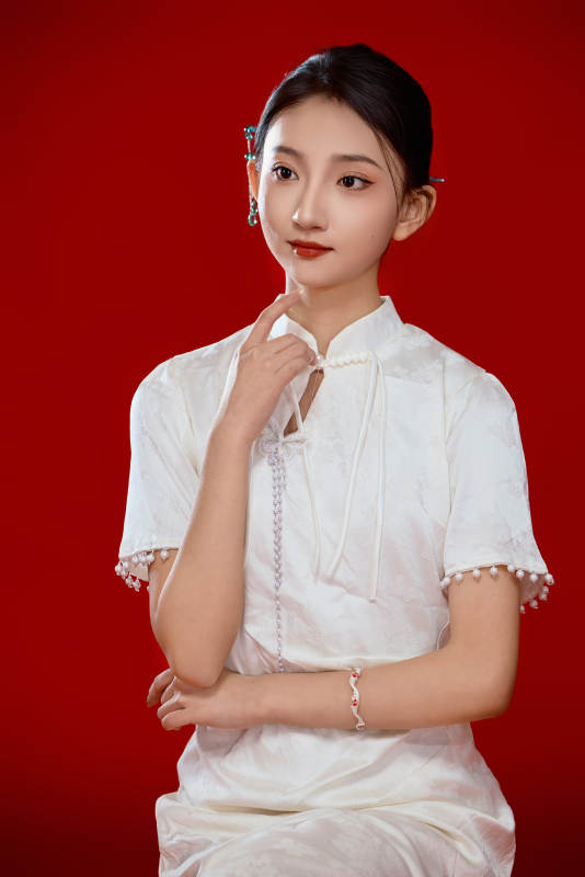 红色背景下穿着中式传统旗袍的美丽少女