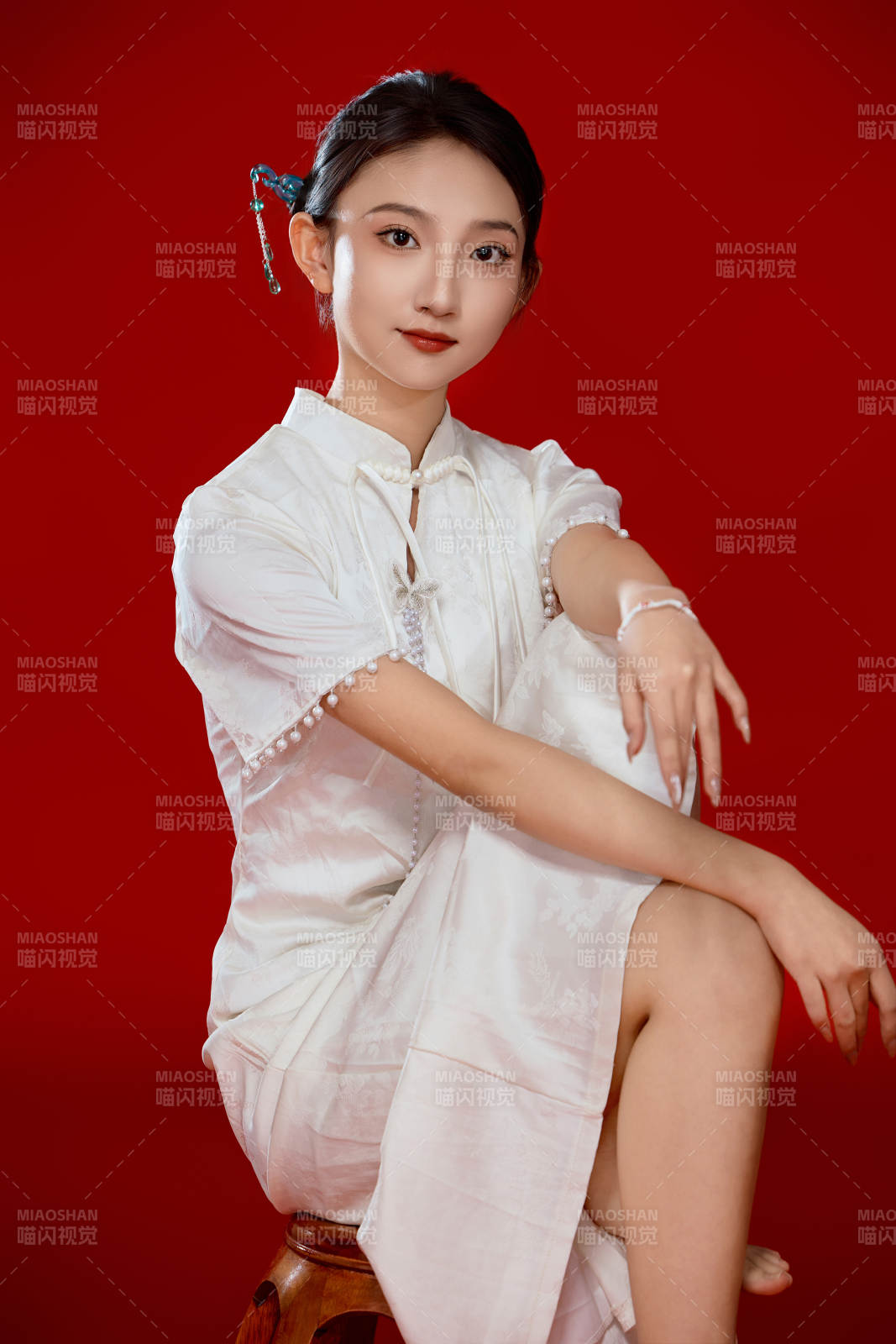 红色背景下穿着中式传统旗袍的美丽少女