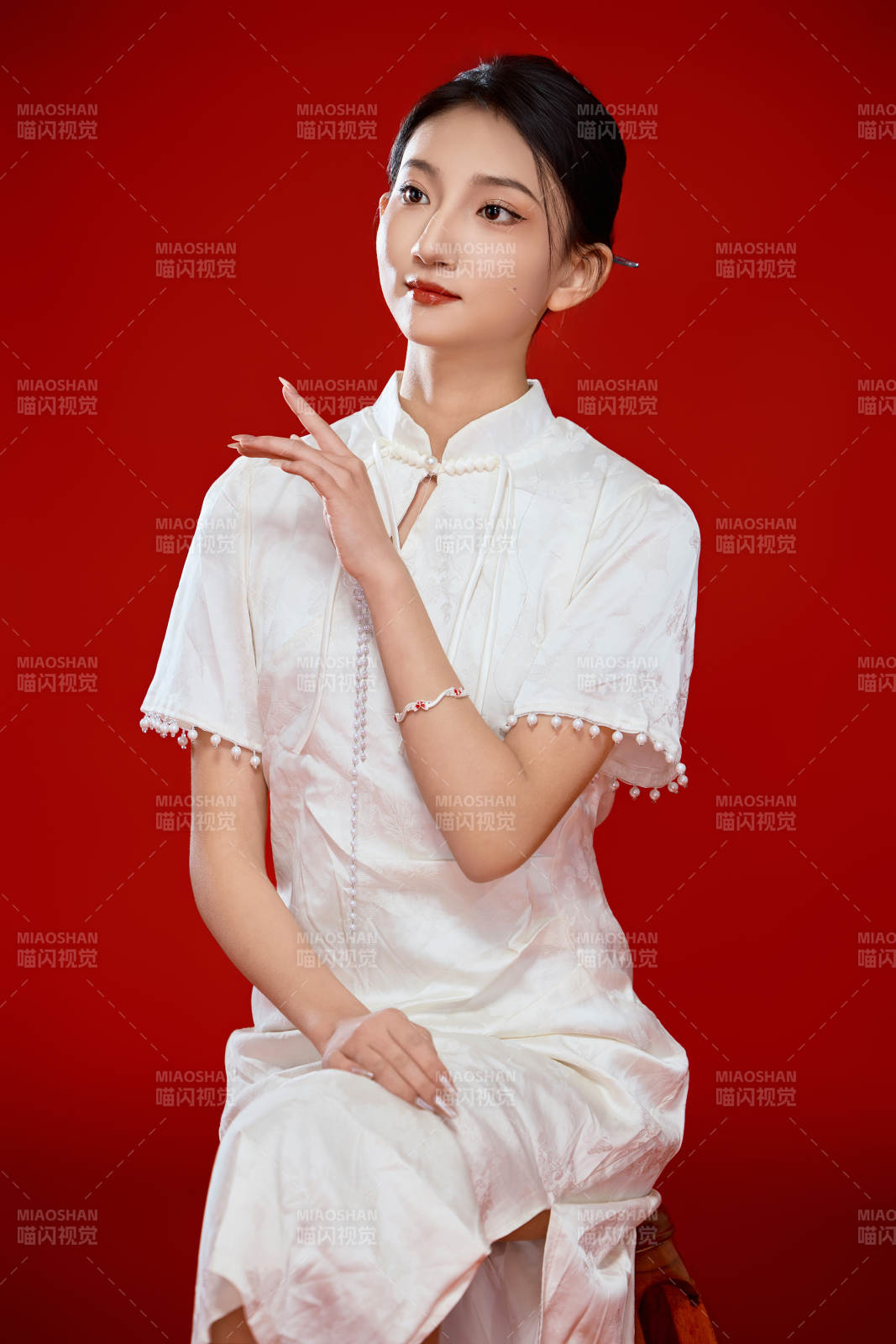 紅色背景下穿著中式傳統(tǒng)旗袍的美麗少女