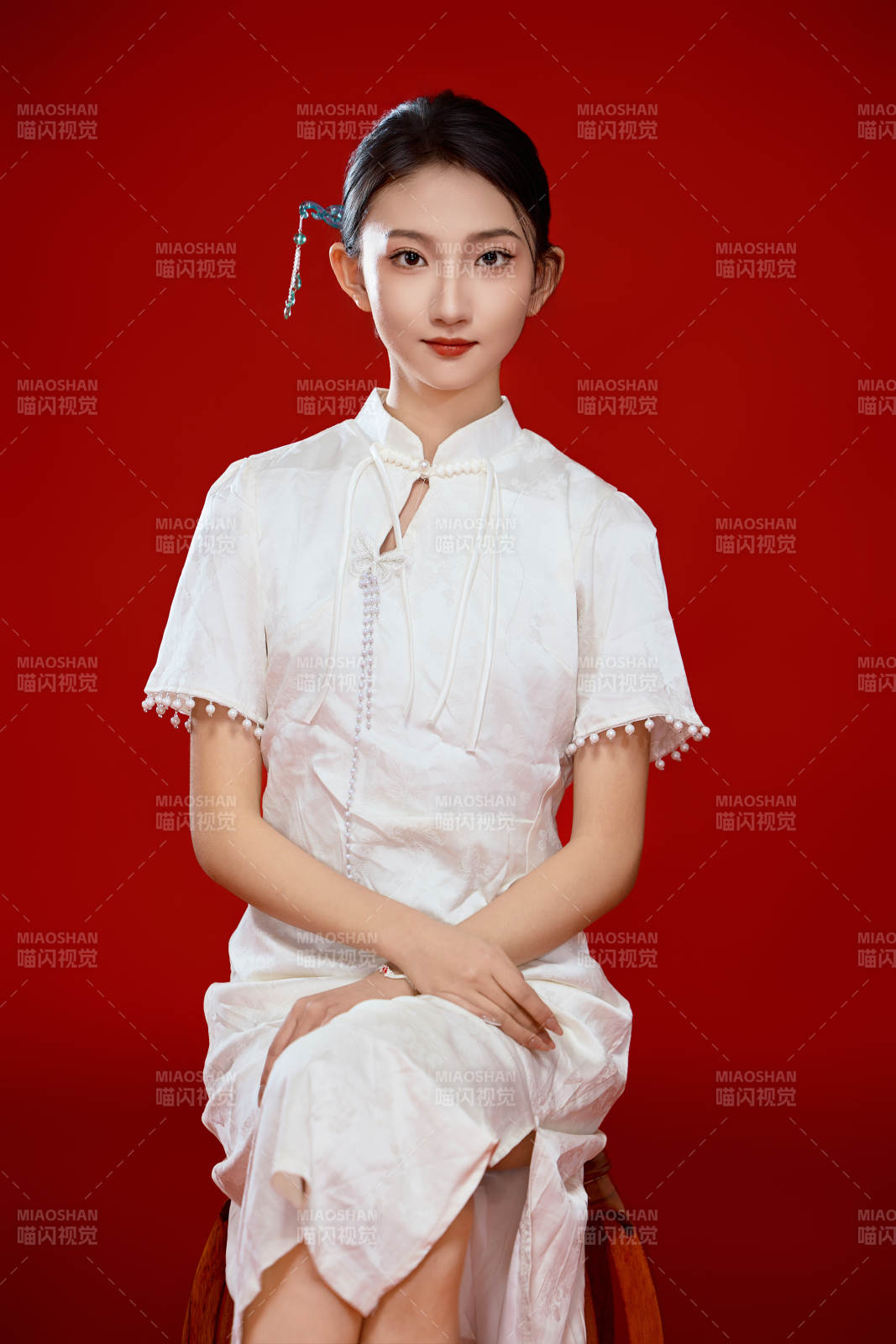 红色背景下穿着中式传统旗袍的美丽少女