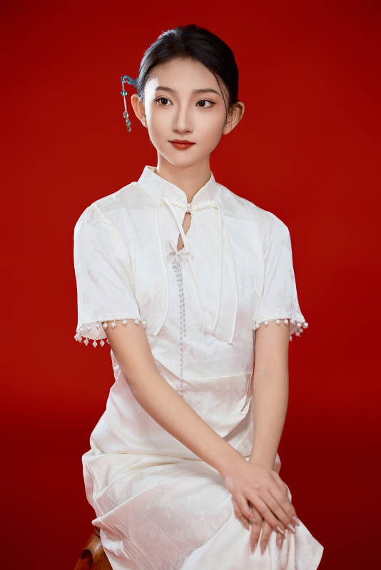红色背景下穿着中式传统旗袍的美丽少女