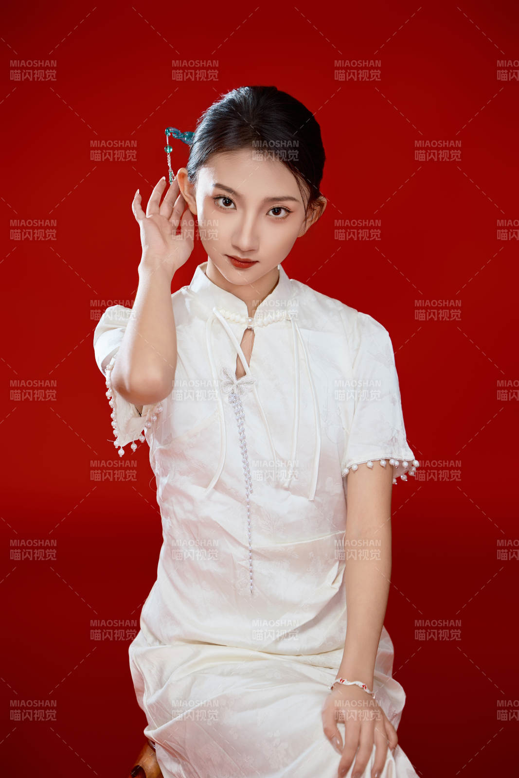 红色背景下穿着中式传统旗袍的美丽少女