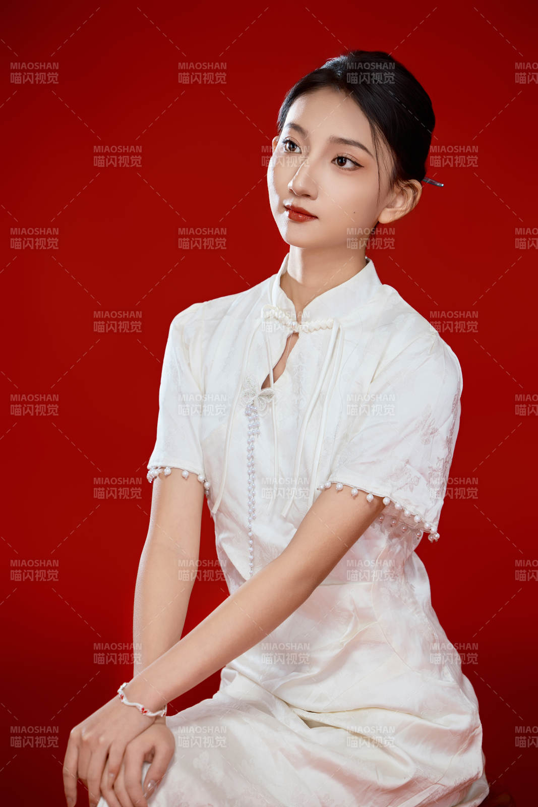 红色背景下穿着中式传统旗袍的美丽少女