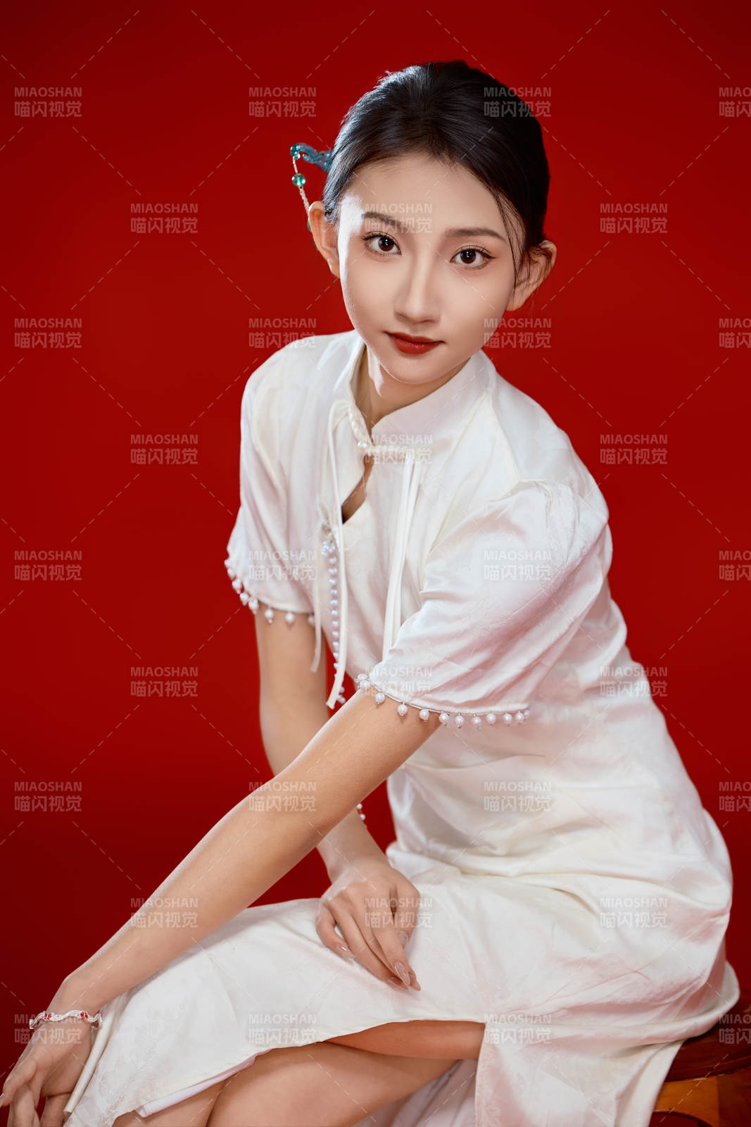 红色背景下穿着中式传统旗袍的美丽少女