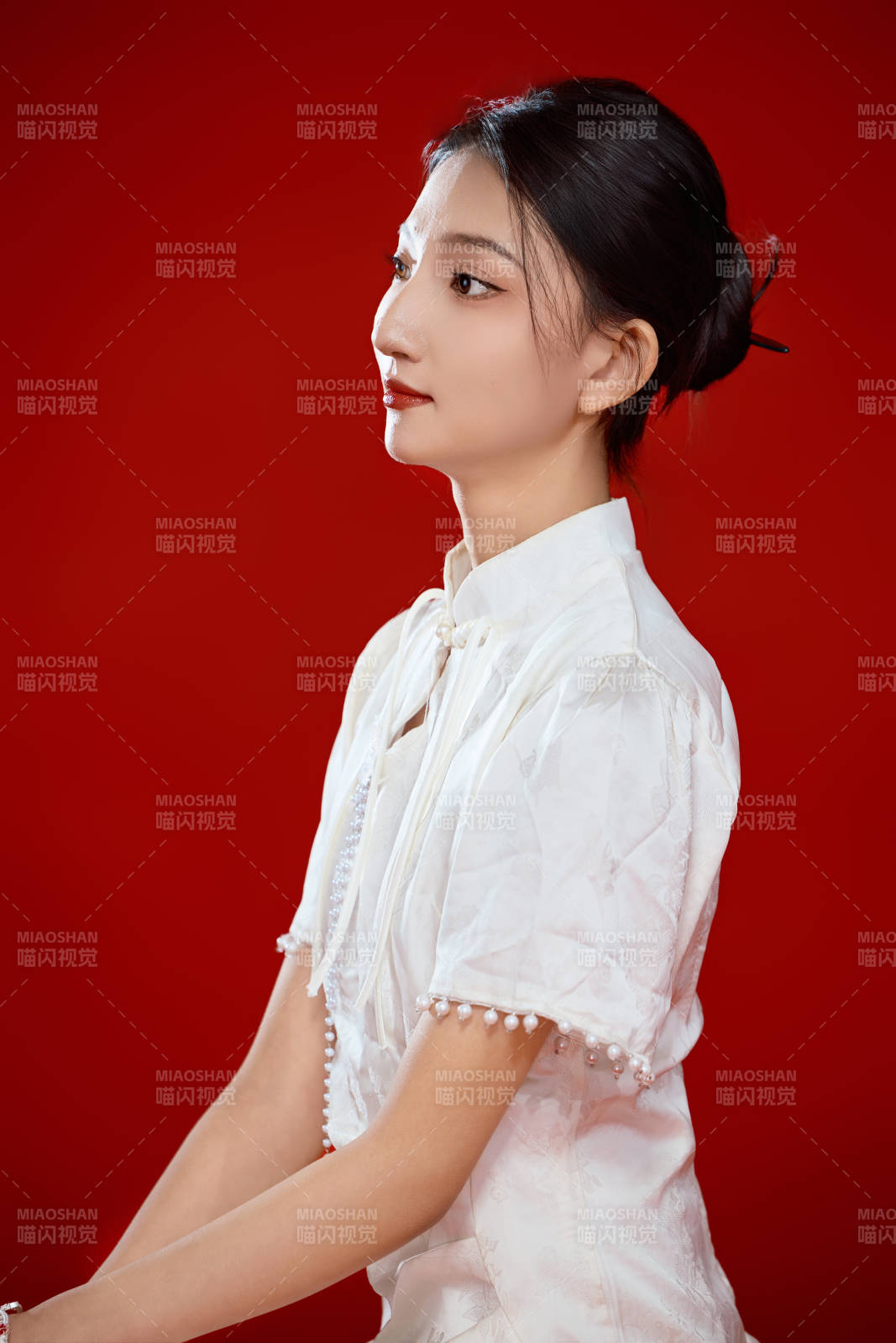 红色背景下穿着中式传统旗袍的美丽少女