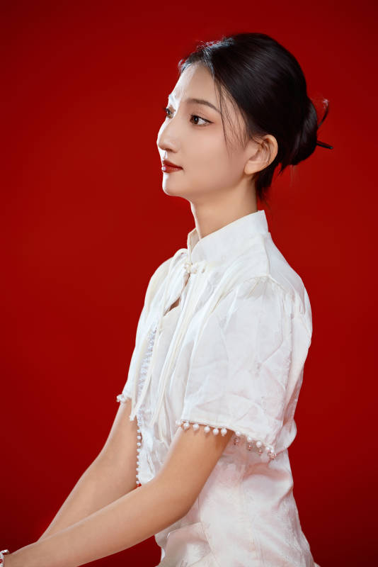 红色背景下穿着中式传统旗袍的美丽少女