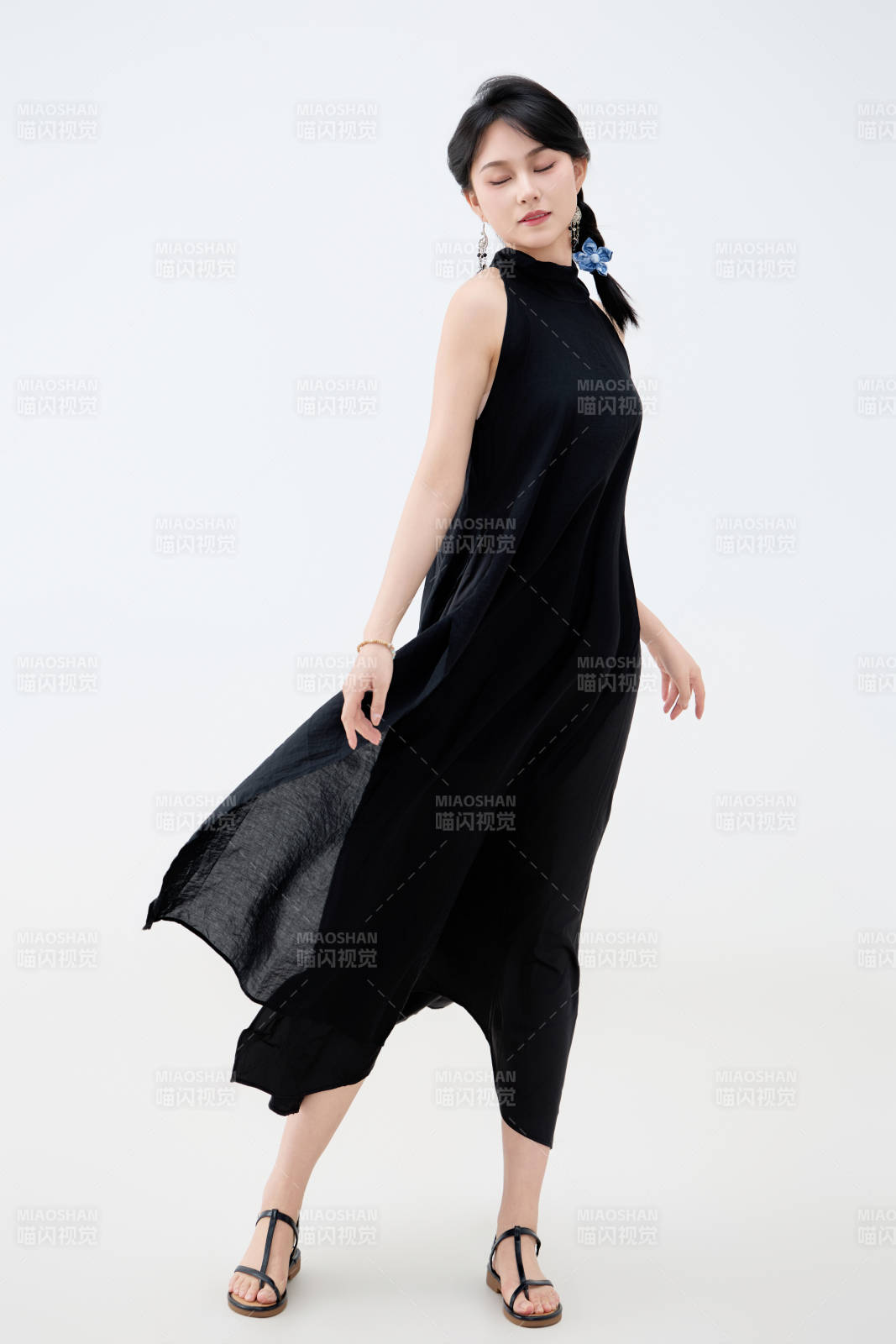 影棚拍攝穿著黑色連體裙的夏日出行美女