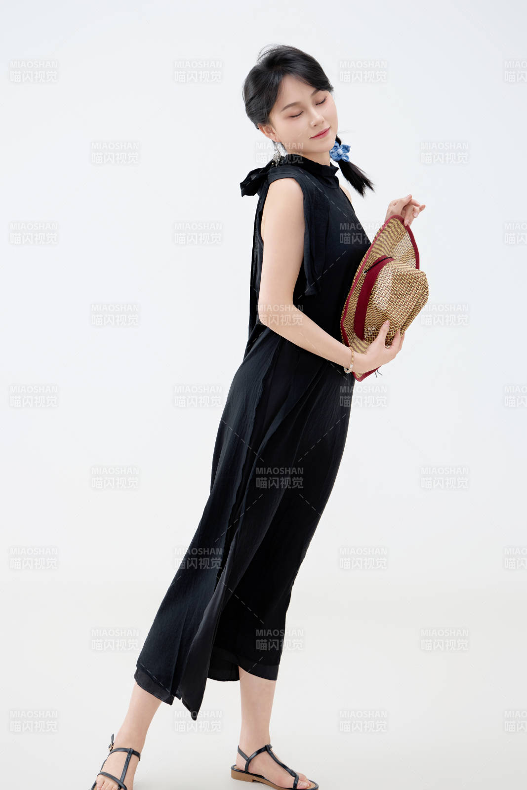 影棚拍摄穿着黑色连体裙的夏日出行美女