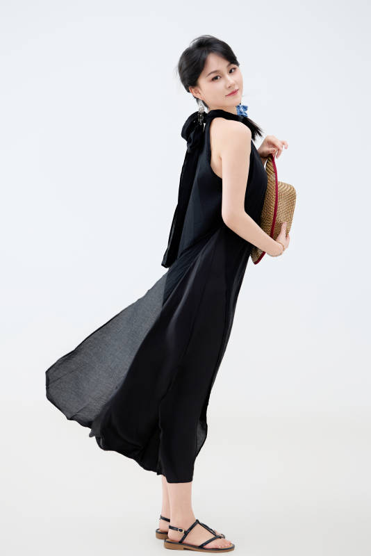 影棚拍摄穿着黑色连体裙的夏日出行美女