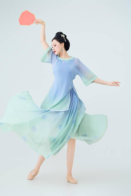 穿着中式古典服饰表演古典舞的美丽舞者