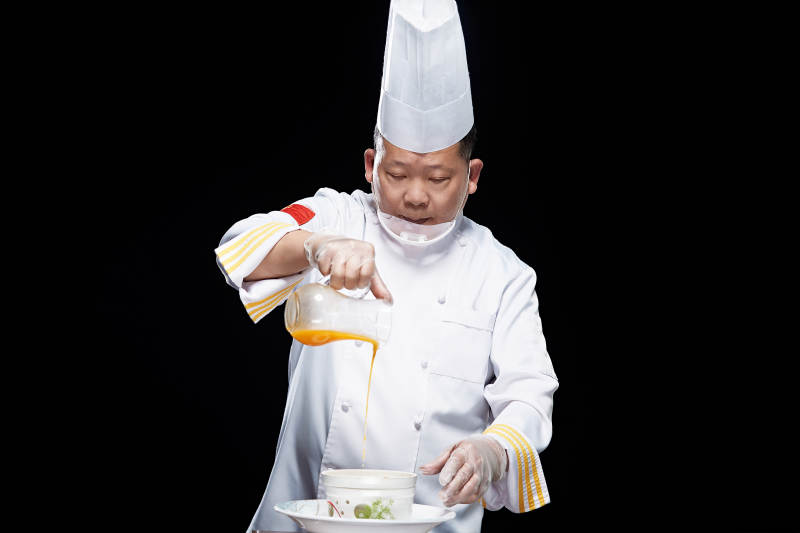 精心制作菜品的高級粵菜廚師