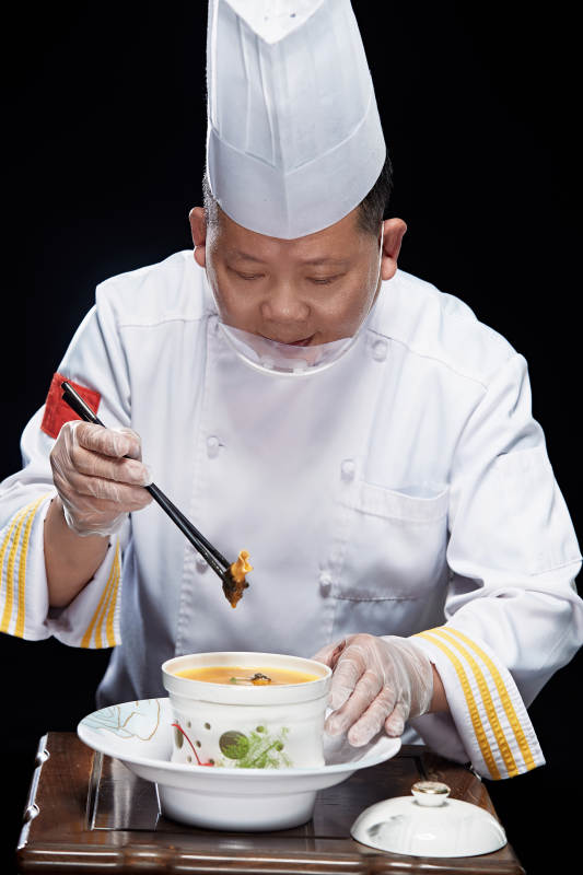 精心制作菜品的高级粤菜厨师