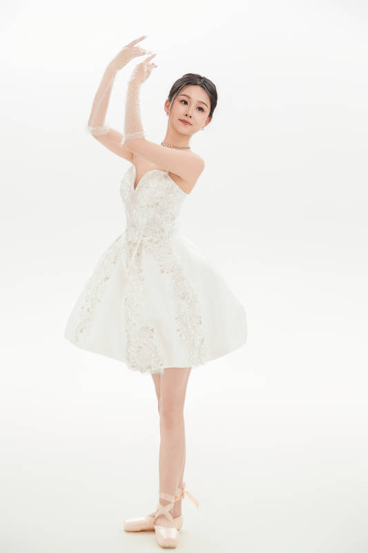 白色背景下跳芭蕾舞的亚洲少女