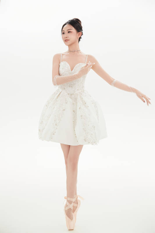 白色背景下跳芭蕾舞的亚洲少女