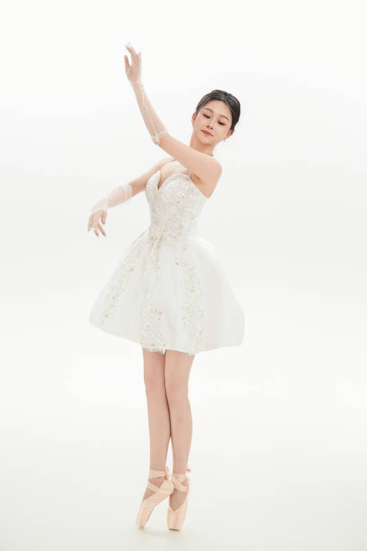 白色背景下跳芭蕾舞的亚洲少女