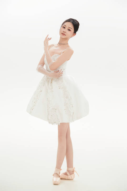 白色背景下跳芭蕾舞的亚洲少女