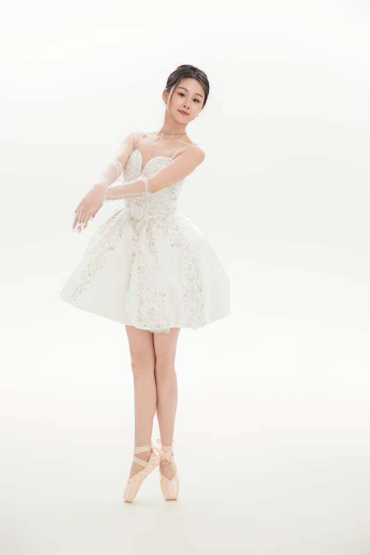 白色背景下跳芭蕾舞的亚洲少女