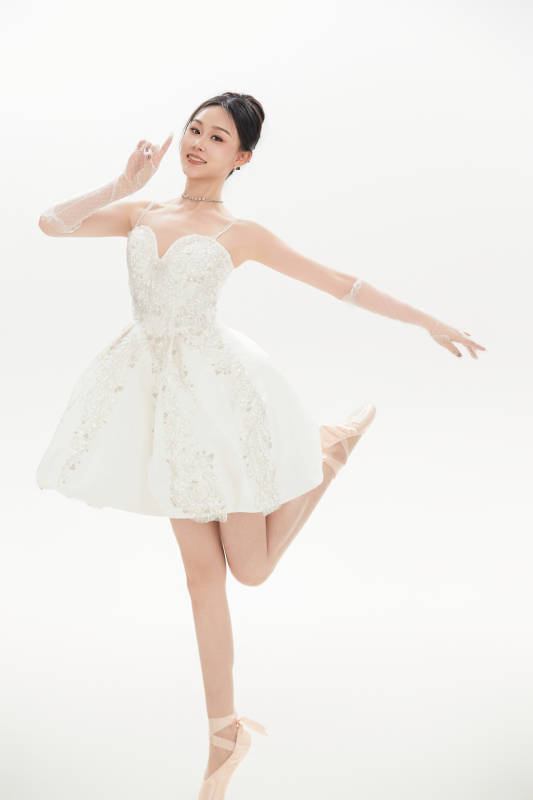 白色背景下跳芭蕾舞的亚洲少女