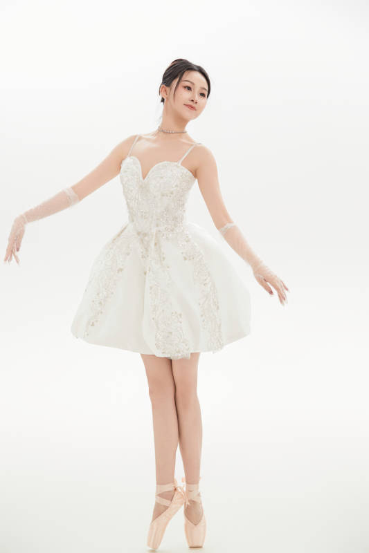 白色背景下跳芭蕾舞的亚洲少女