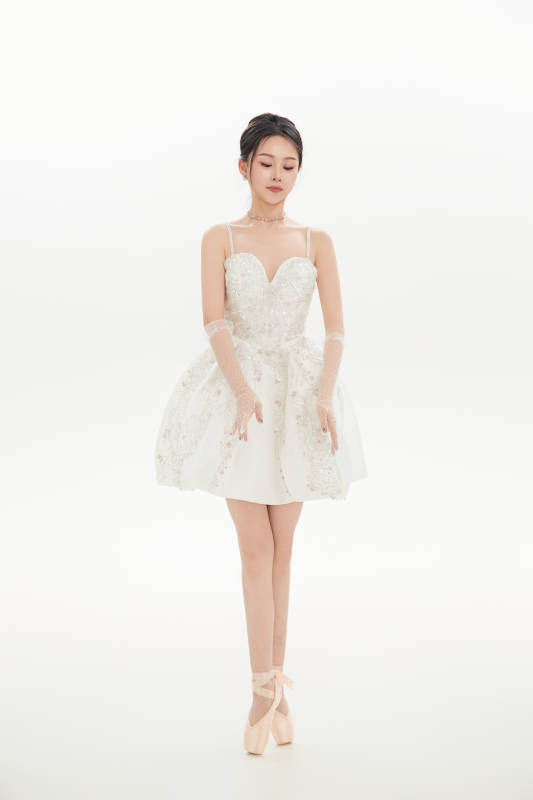 白色背景下跳芭蕾舞的亚洲少女